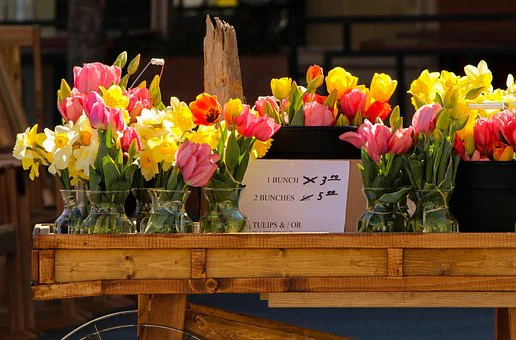 Flores dispostas em recipientes em um ponto de venda