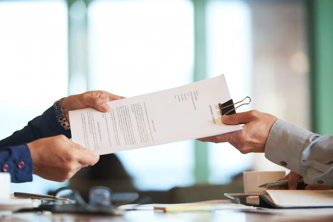 Pessoas conferindo documentos sobre uma mesa